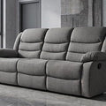 Gray sofa in a modern living room with large windows and a plant.